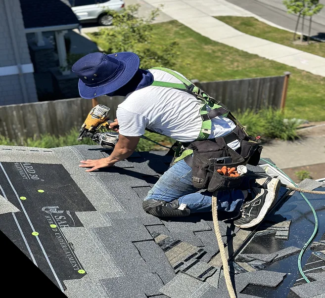 Brixton & Windsor crew rolling underlayment across a stripped roof deck