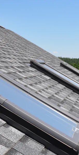 Skylight seated in a gray asphalt shingle roof